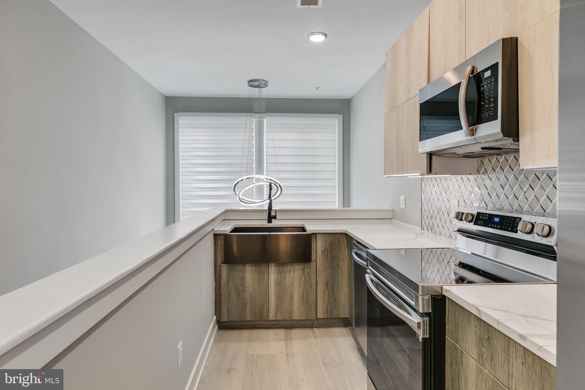 a kitchen with stainless steel appliances a stove a sink and a microwave