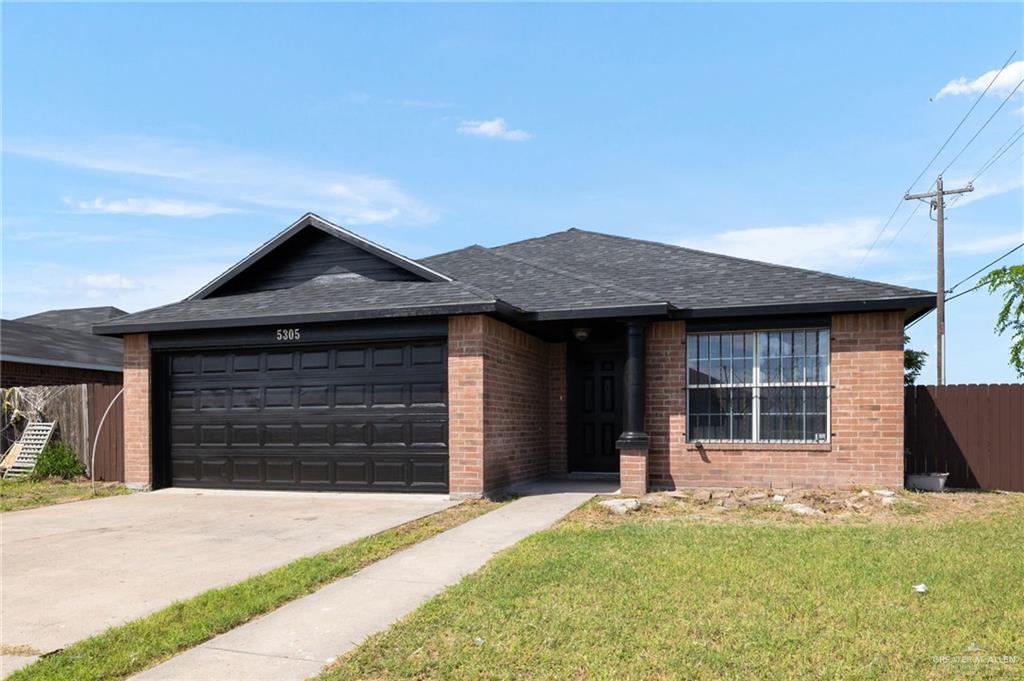 View of front of home featuring a garage and a front lawn