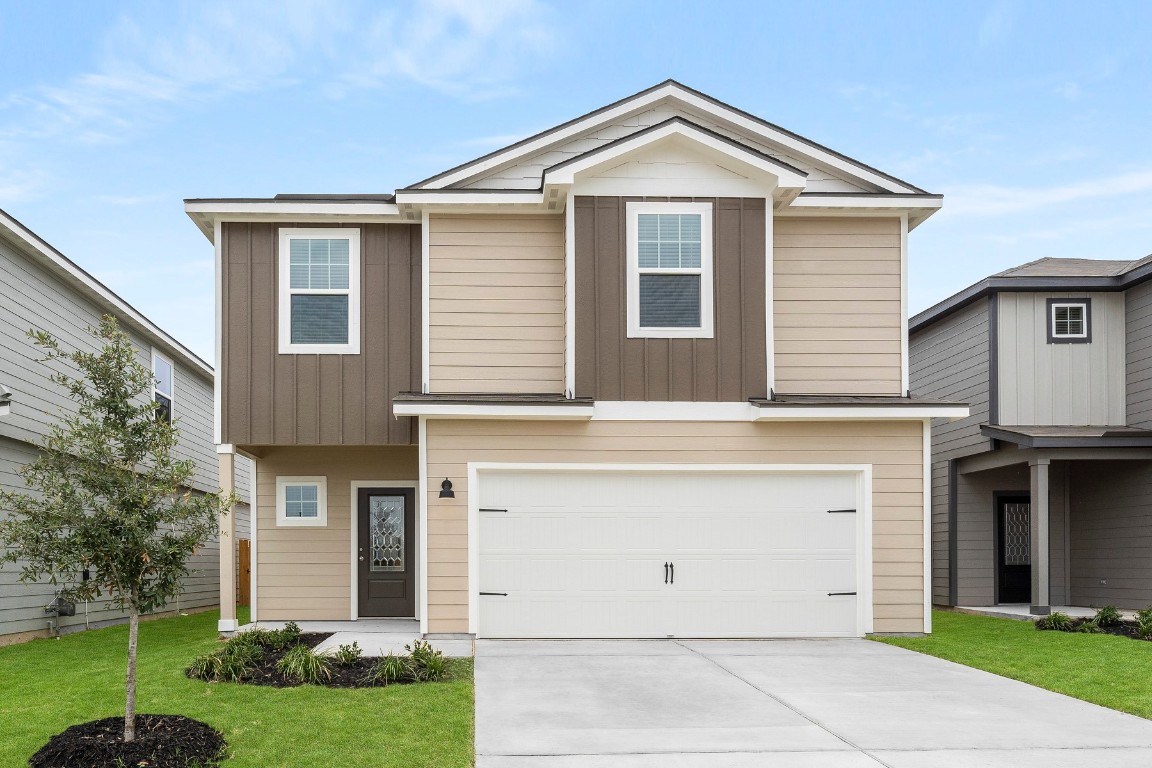 a front view of a house with a yard and garage