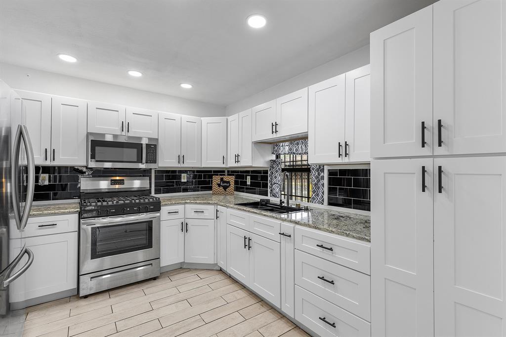 a kitchen with white cabinets stainless steel appliances and sink