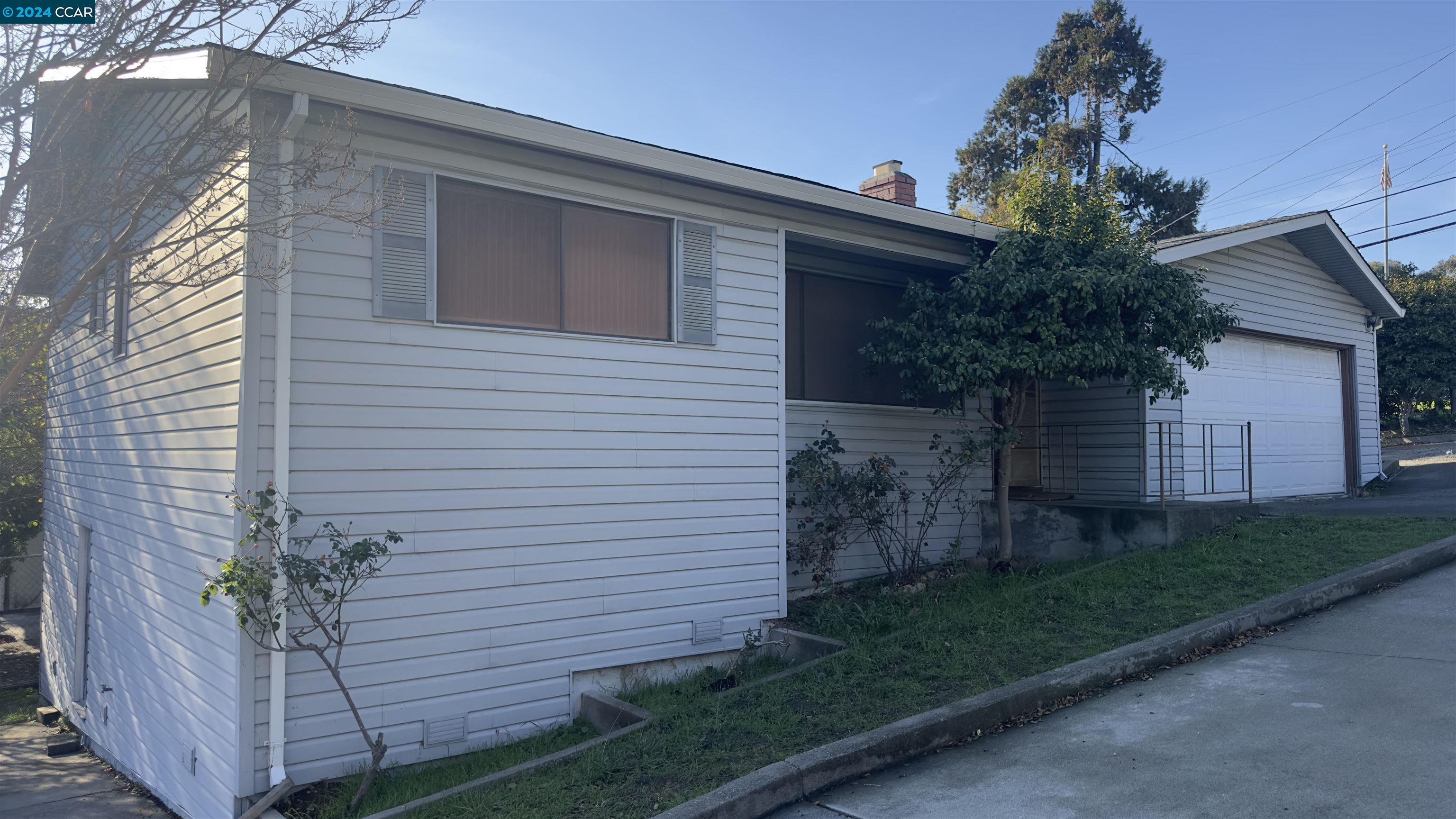 a view of a house with a yard and potted plants