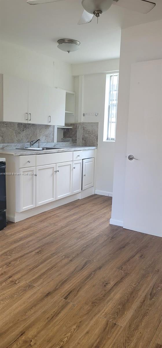 a view of a kitchen with wooden floor and a sink