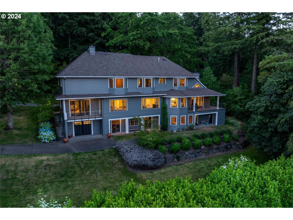 a aerial view of a house next to a big yard and large trees