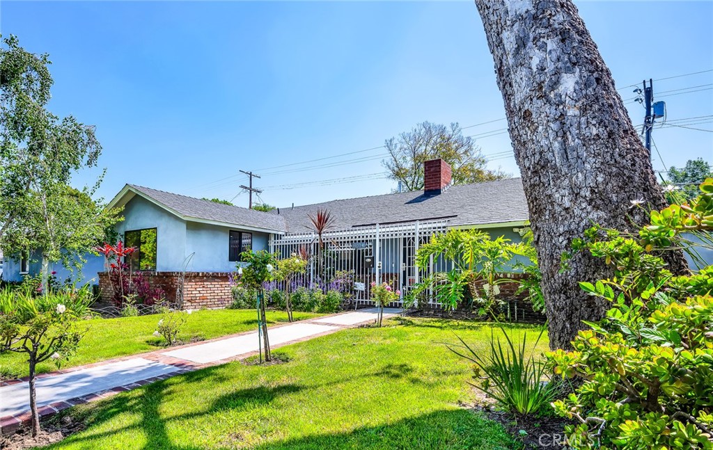 a view of a house next to a yard with potted plants