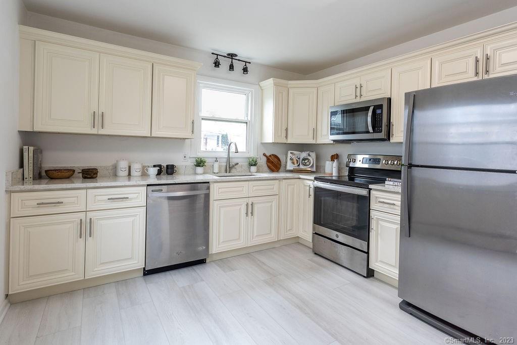 a kitchen with white cabinets stainless steel appliances and sink