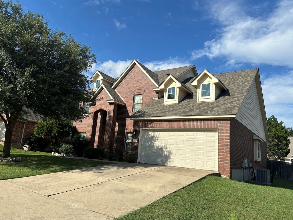 a front view of a house with a garden and yard