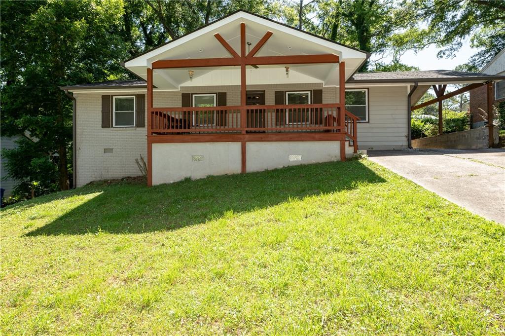 a view of a house with a yard and sitting area