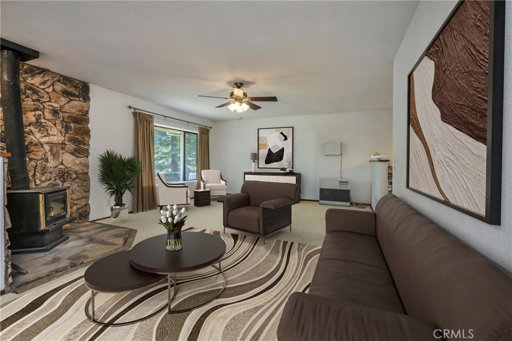 a living room with furniture a large window and wooden floor