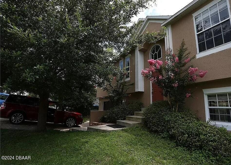 a backyard of a house with plants and tree