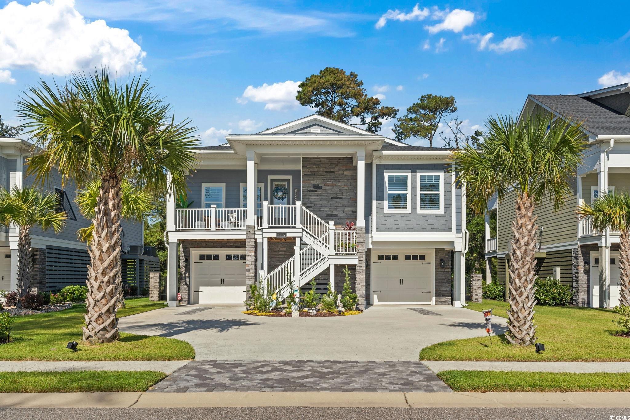 Beach home with a garage, covered porch, and a fro