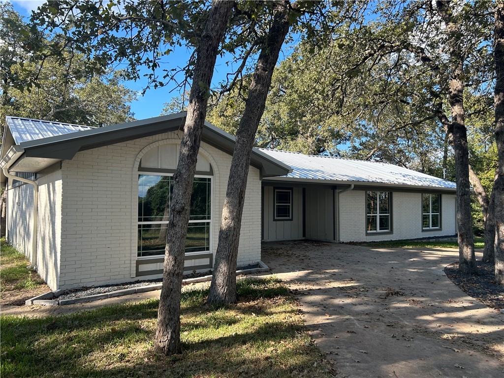 a view of a house with backyard and a tree