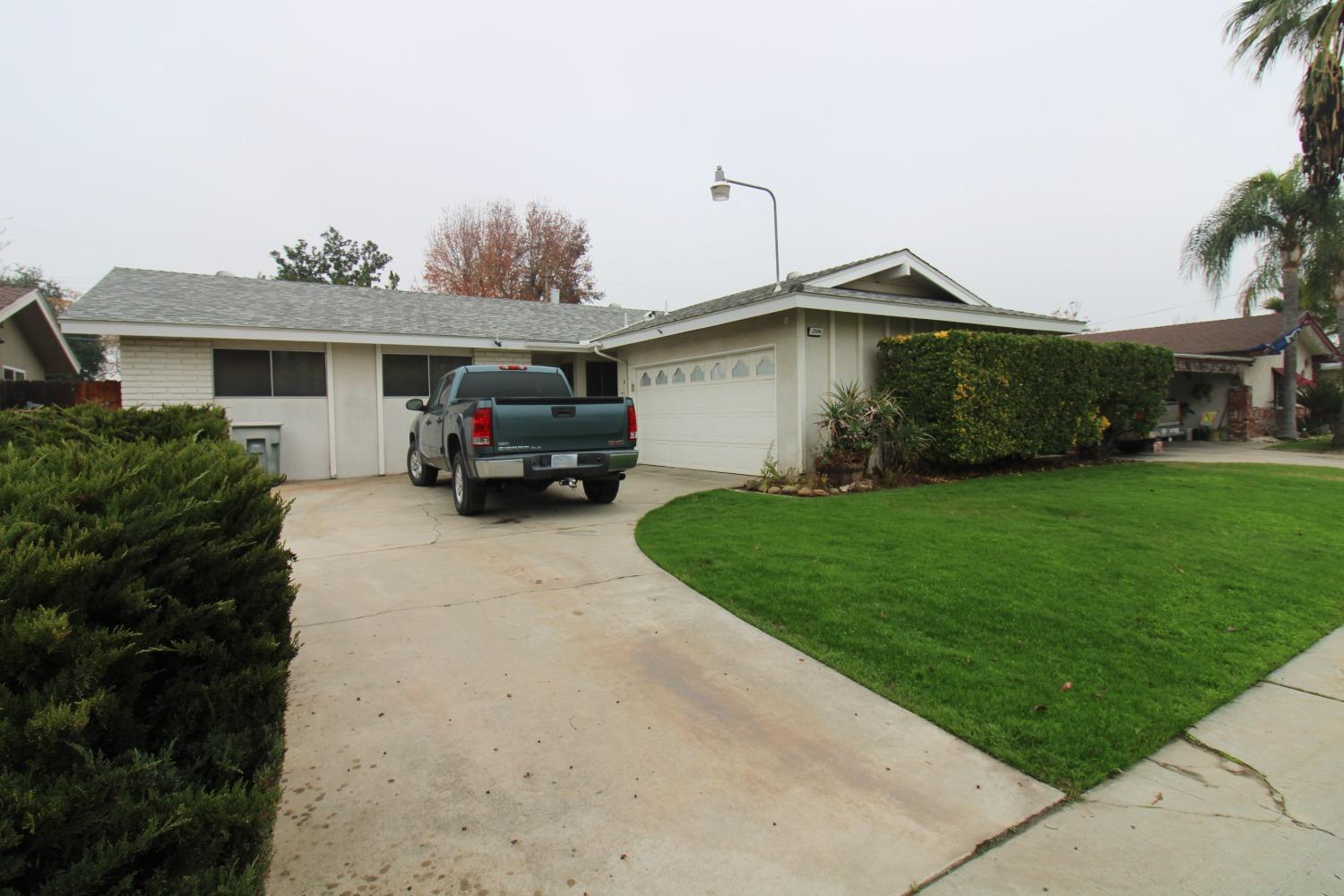 a car parked in front of a house with a yard