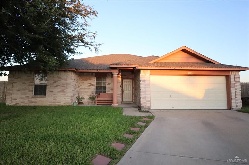 View of front of house featuring a garage and a front lawn