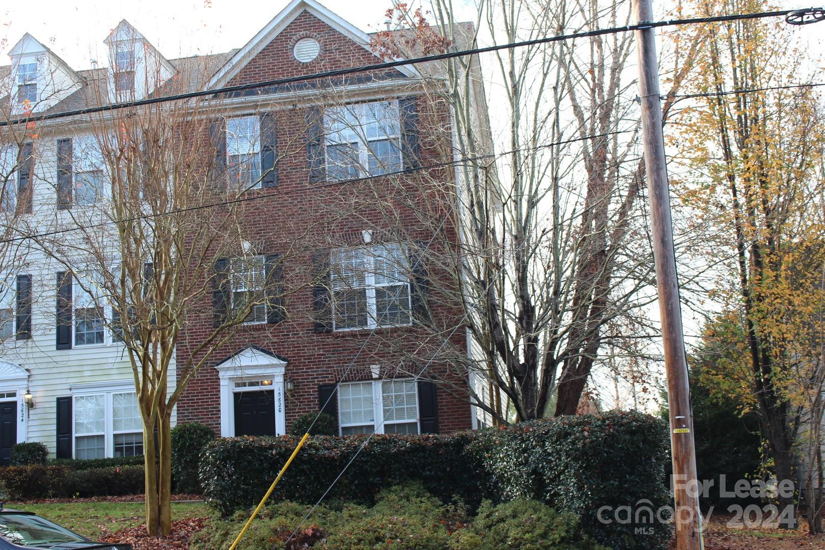 a front view of a house with a yard and tree s