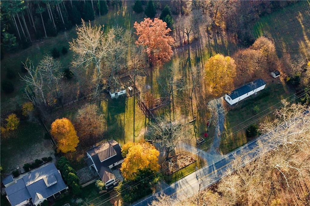 an aerial view of a house with a yard and large trees