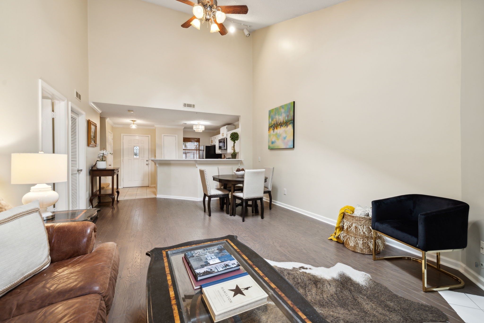 a living room with furniture and a dining table with kitchen view