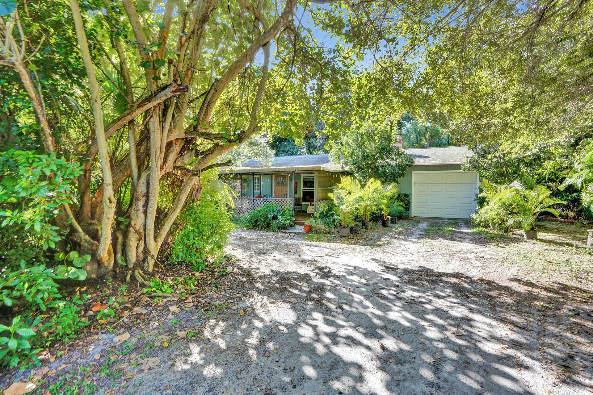 a front view of a house with plants and trees