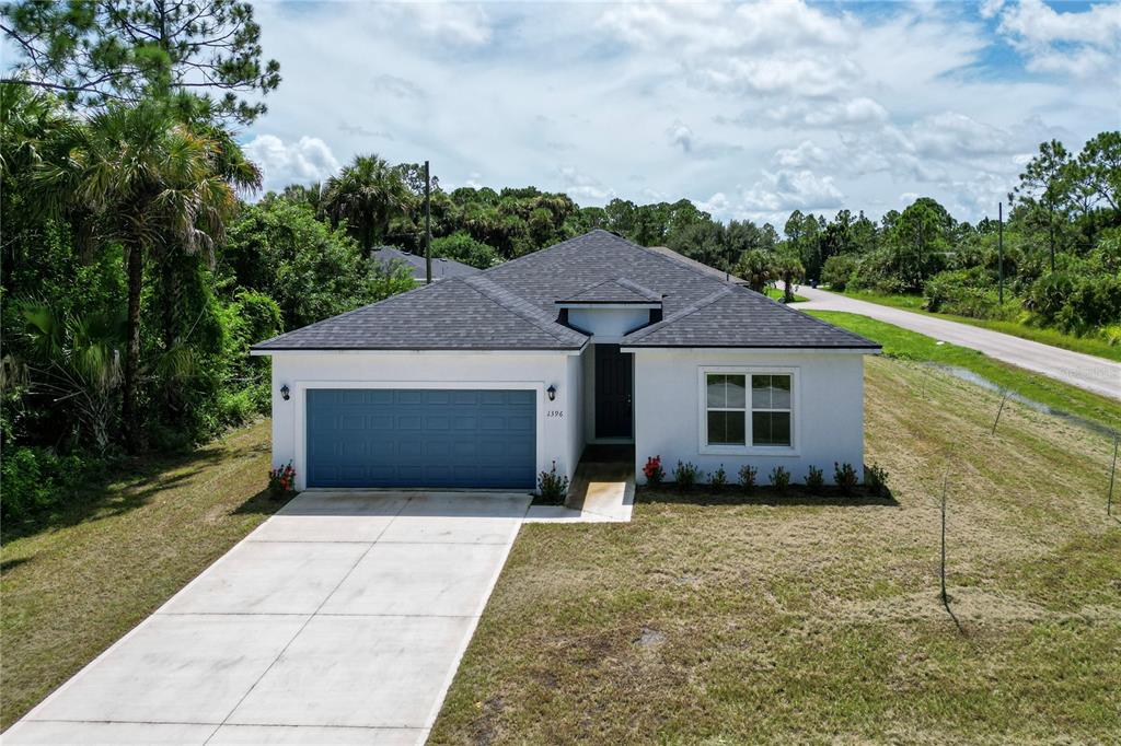 a front view of house with yard and trees around