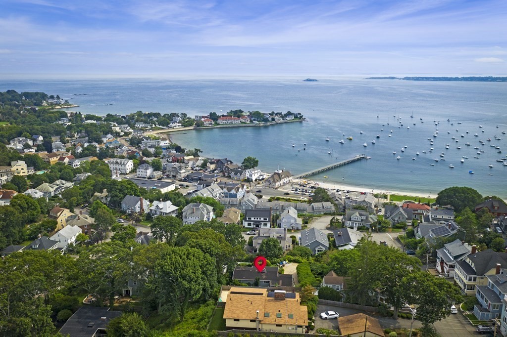 an aerial view of ocean and residential houses with outdoor space