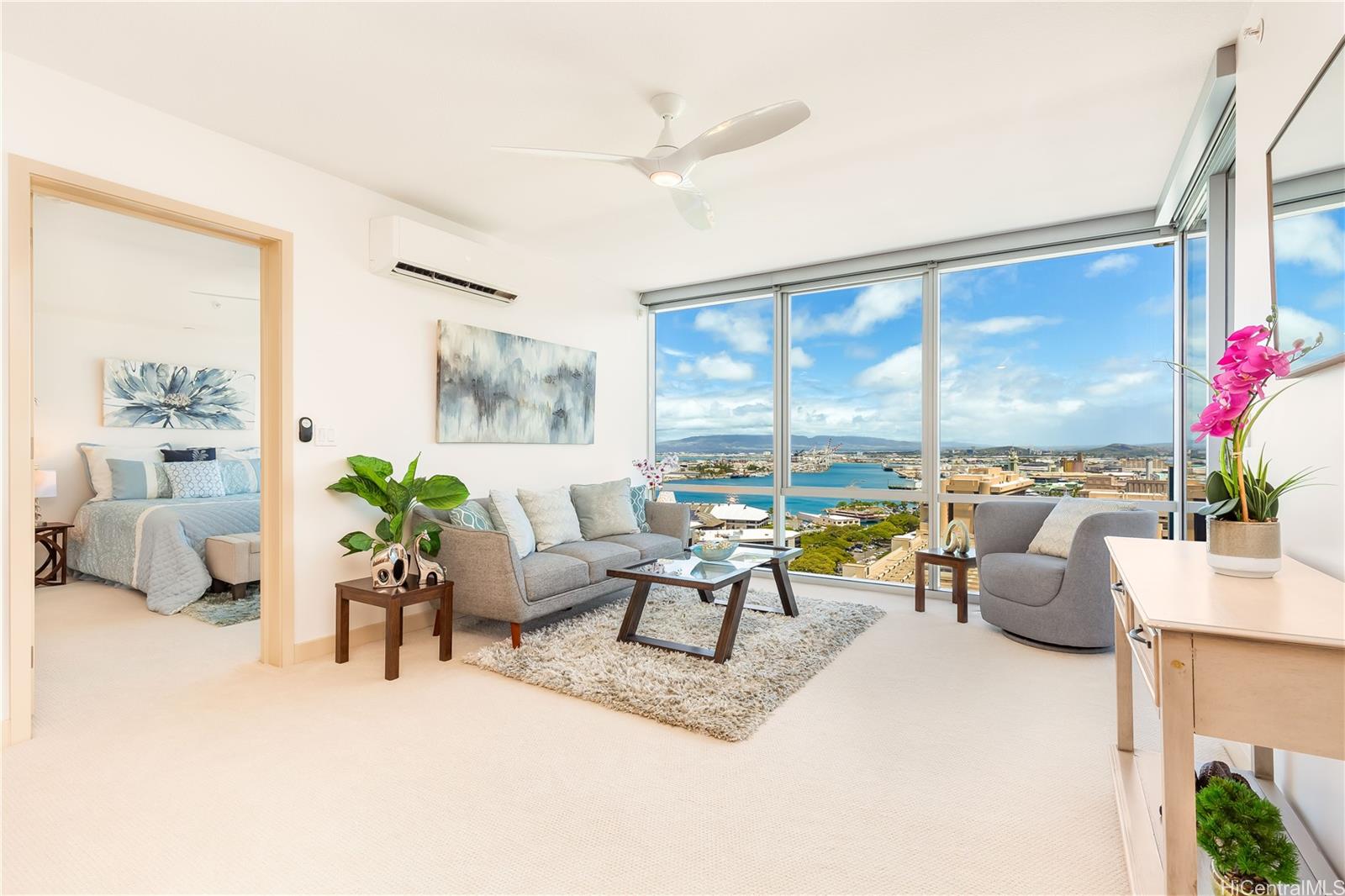 a living room with furniture and floor to ceiling windows