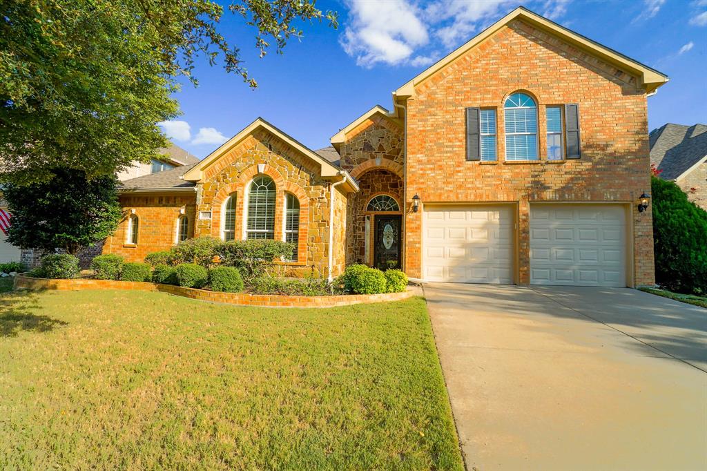 a front view of a house with yard and parking