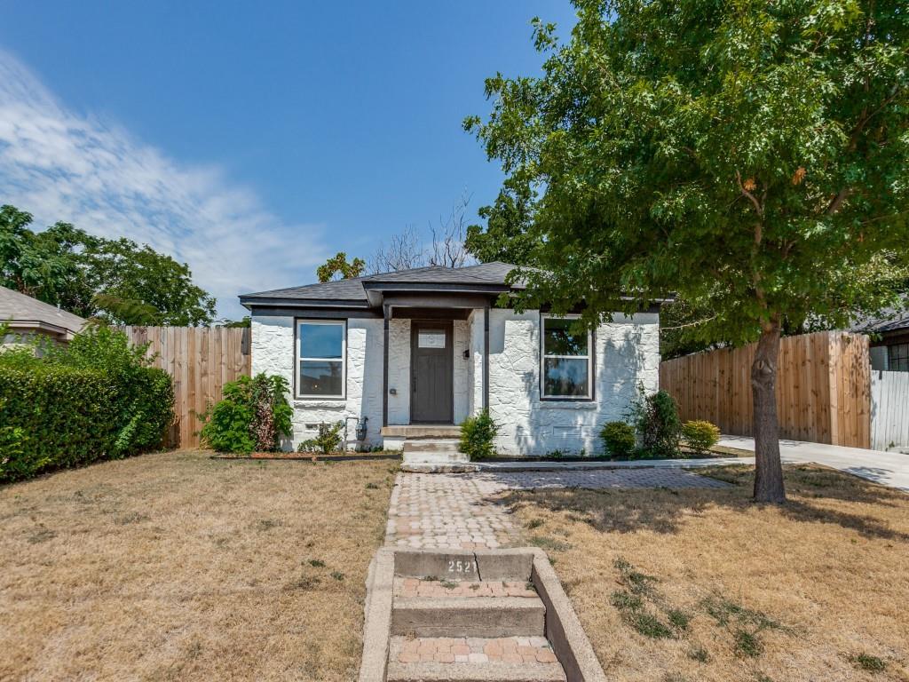 a front view of a house with a yard and potted plants