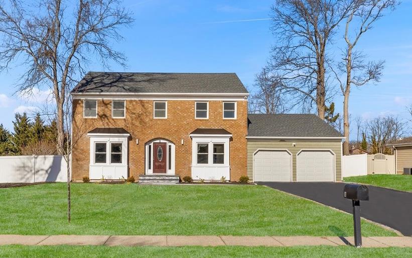 Colonial house with a garage and a front yard