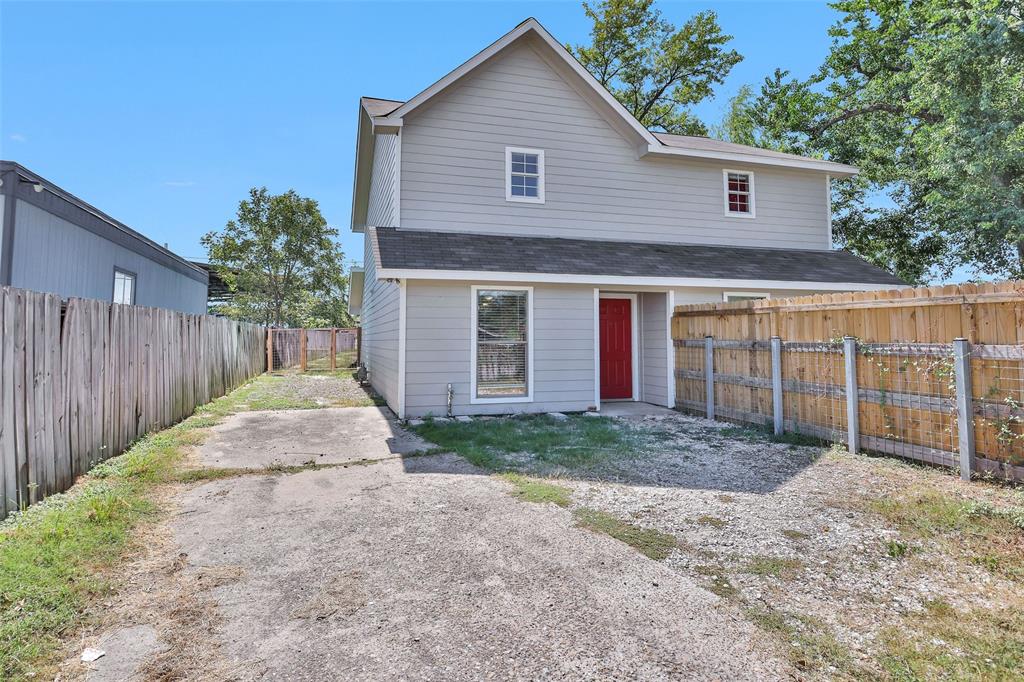 a view of backyard of house with wooden fence