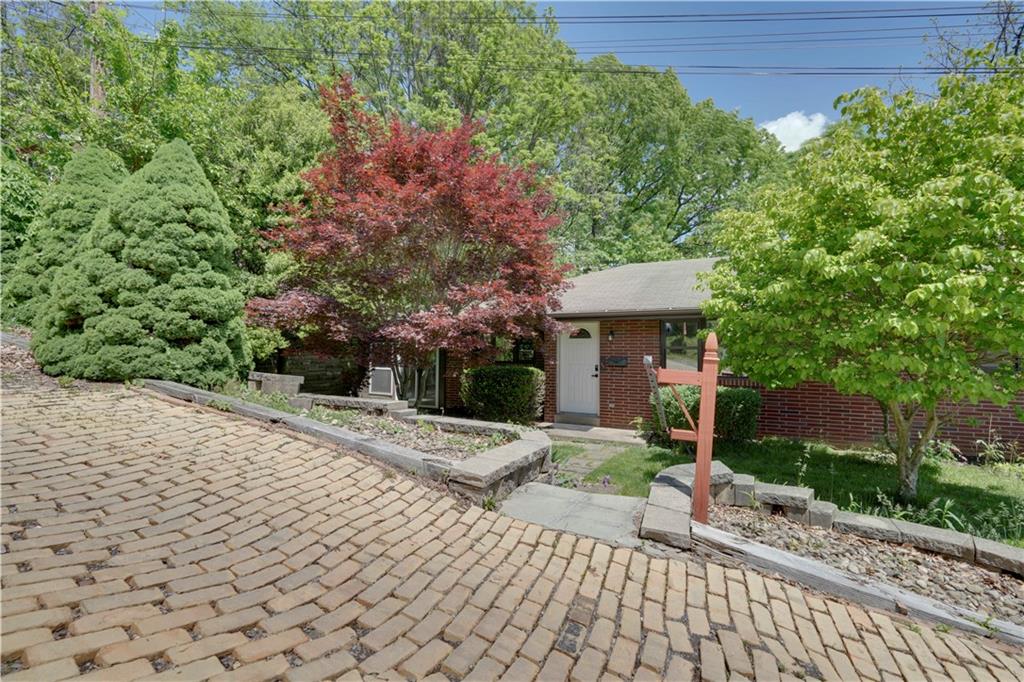 a front view of a house with a yard and trees