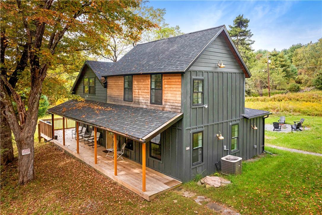 Back of house with cooling unit, a patio area, and a yard