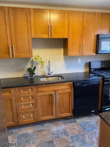 a kitchen with granite countertop cabinets and black stainless steel appliances