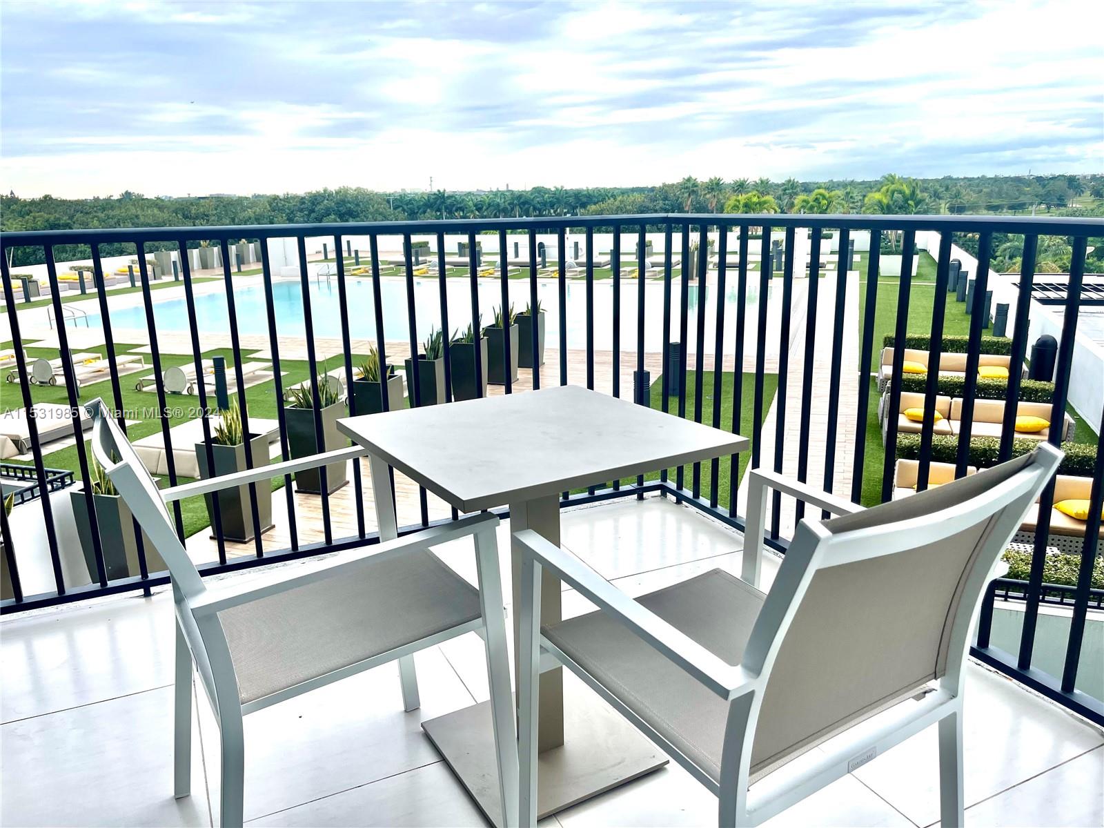 a view of a balcony with wooden floor and outdoor seating