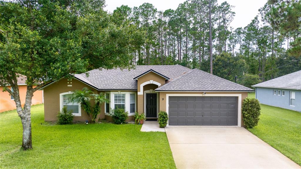 a front view of a house with a garden and yard