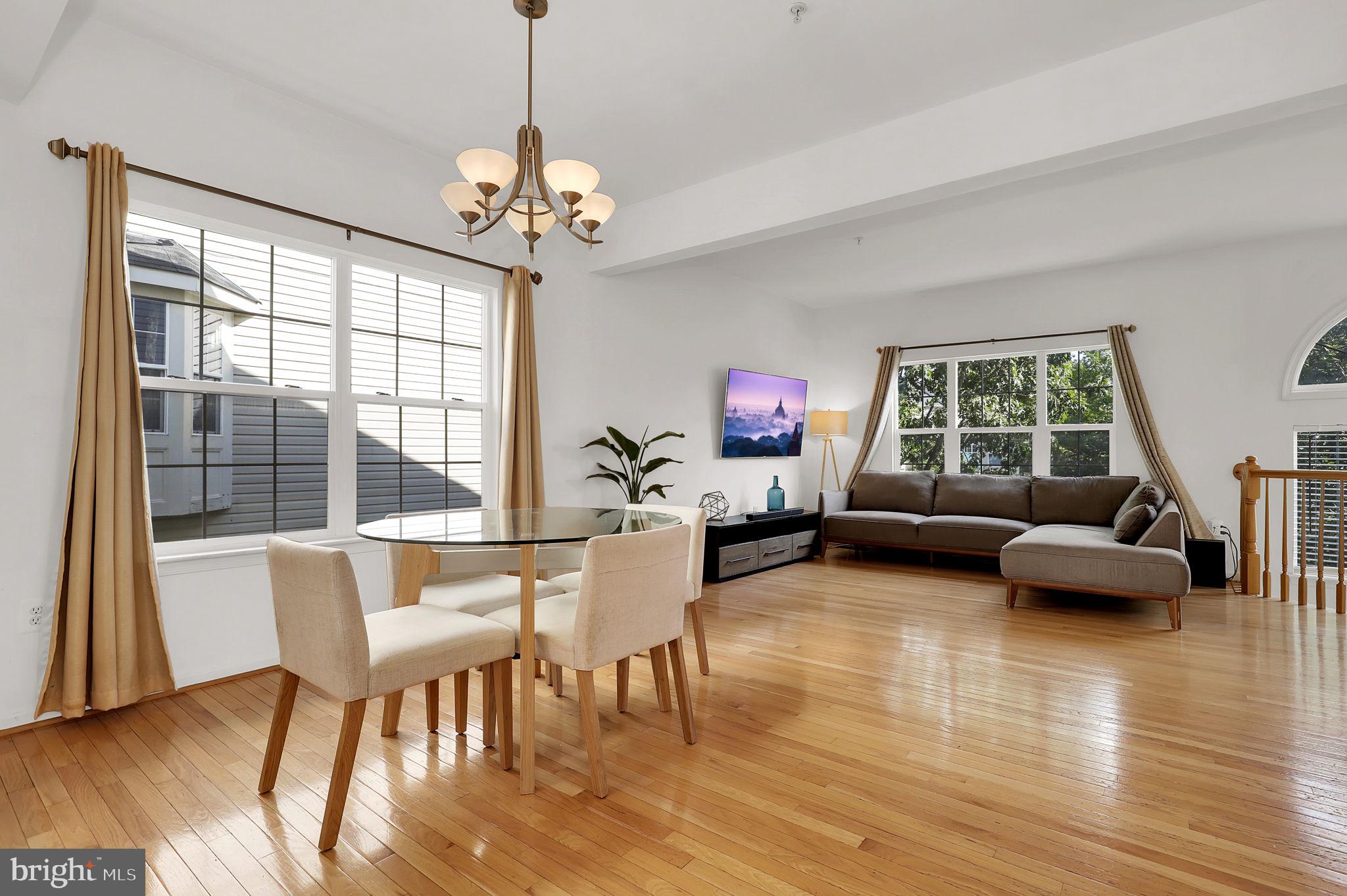 a living room with furniture dining table and a large window