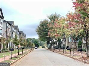 a street with a building and trees in the background