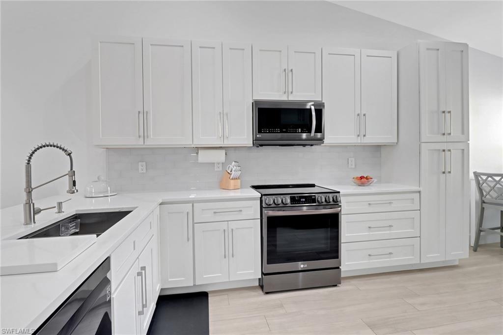 a kitchen with white cabinets and stainless steel appliances