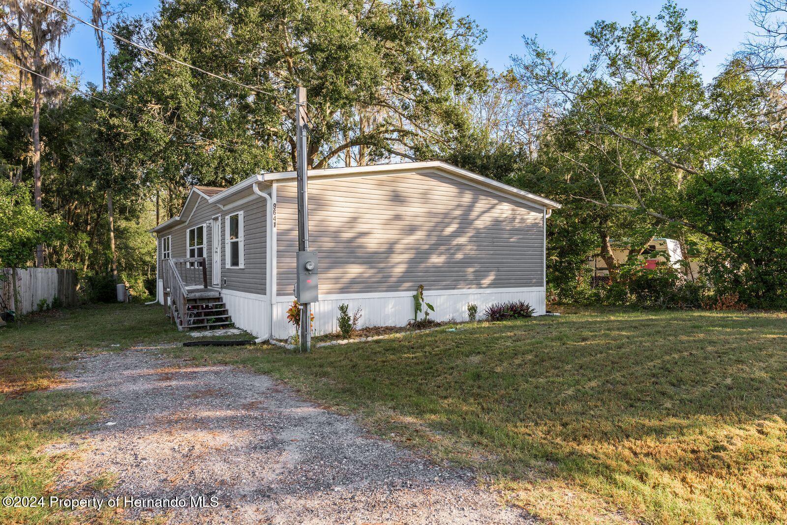 a view of a house with backyard and a tree