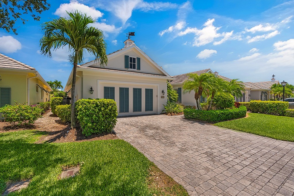 a view of a house with a yard and potted plants