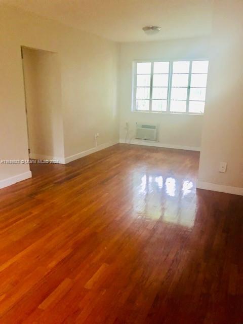 an empty room with wooden floor and windows in it