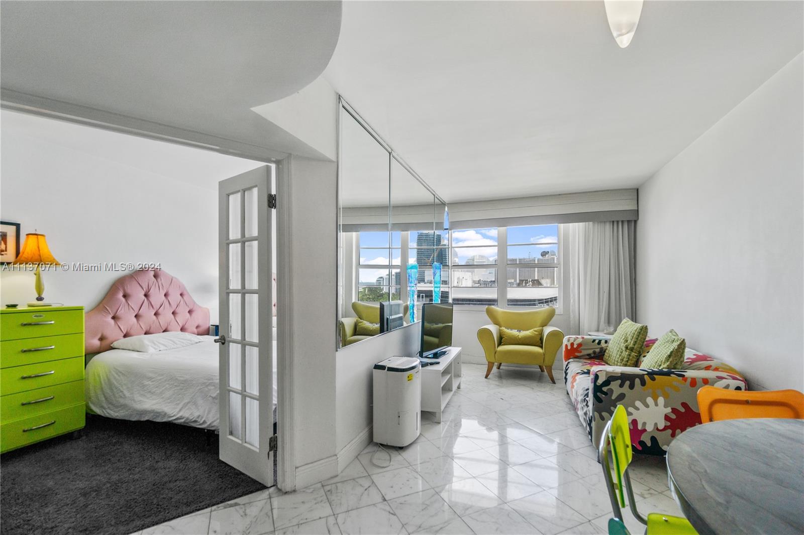 a living room with furniture and a floor to ceiling window