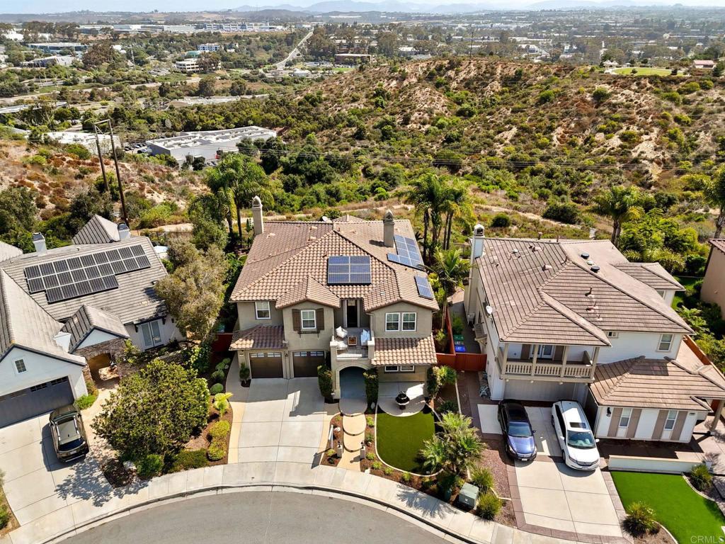 an aerial view of multiple houses with a city street