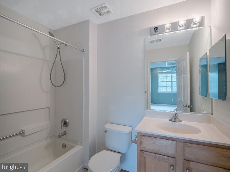 a bathroom with a granite countertop sink a toilet and shower