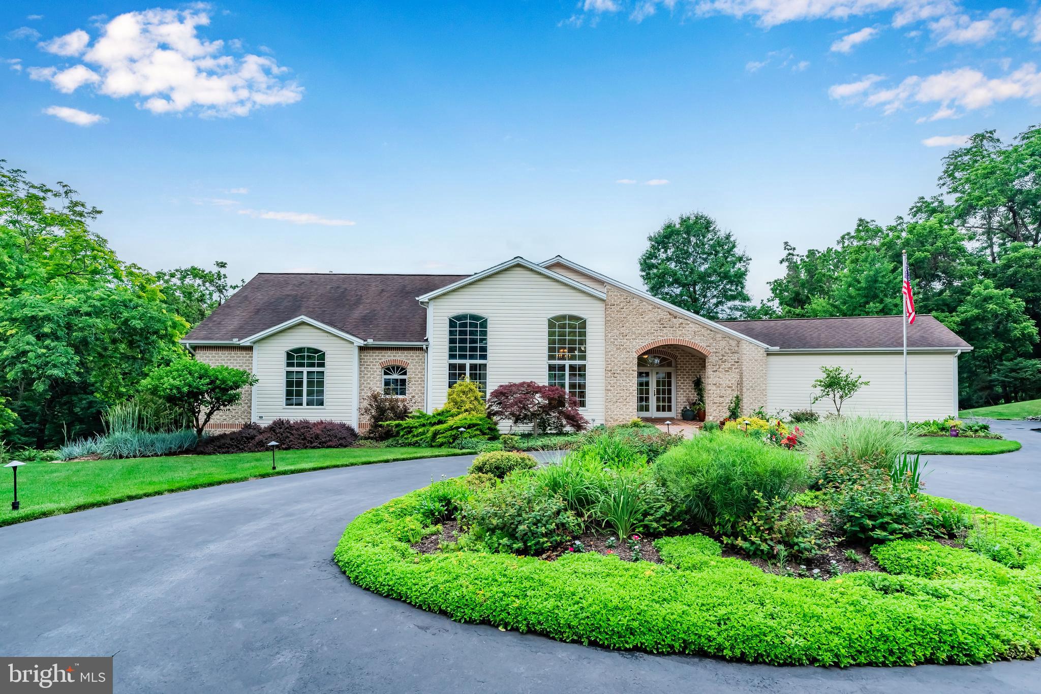 a view of a house with a big yard plants and large trees