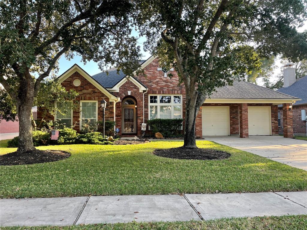 a front view of a house with a yard and trees