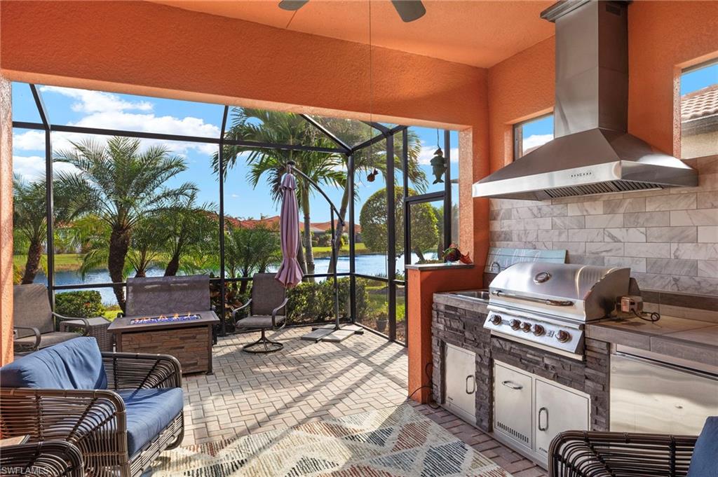 a view of a patio with table and chairs under an umbrella with a fireplace