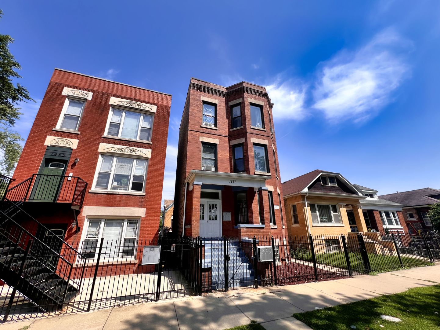 a front view of a residential apartment building with a yard