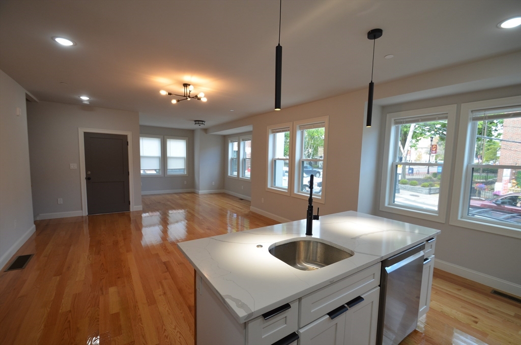 a kitchen with stainless steel appliances granite countertop a sink a oven and a hard wood floor