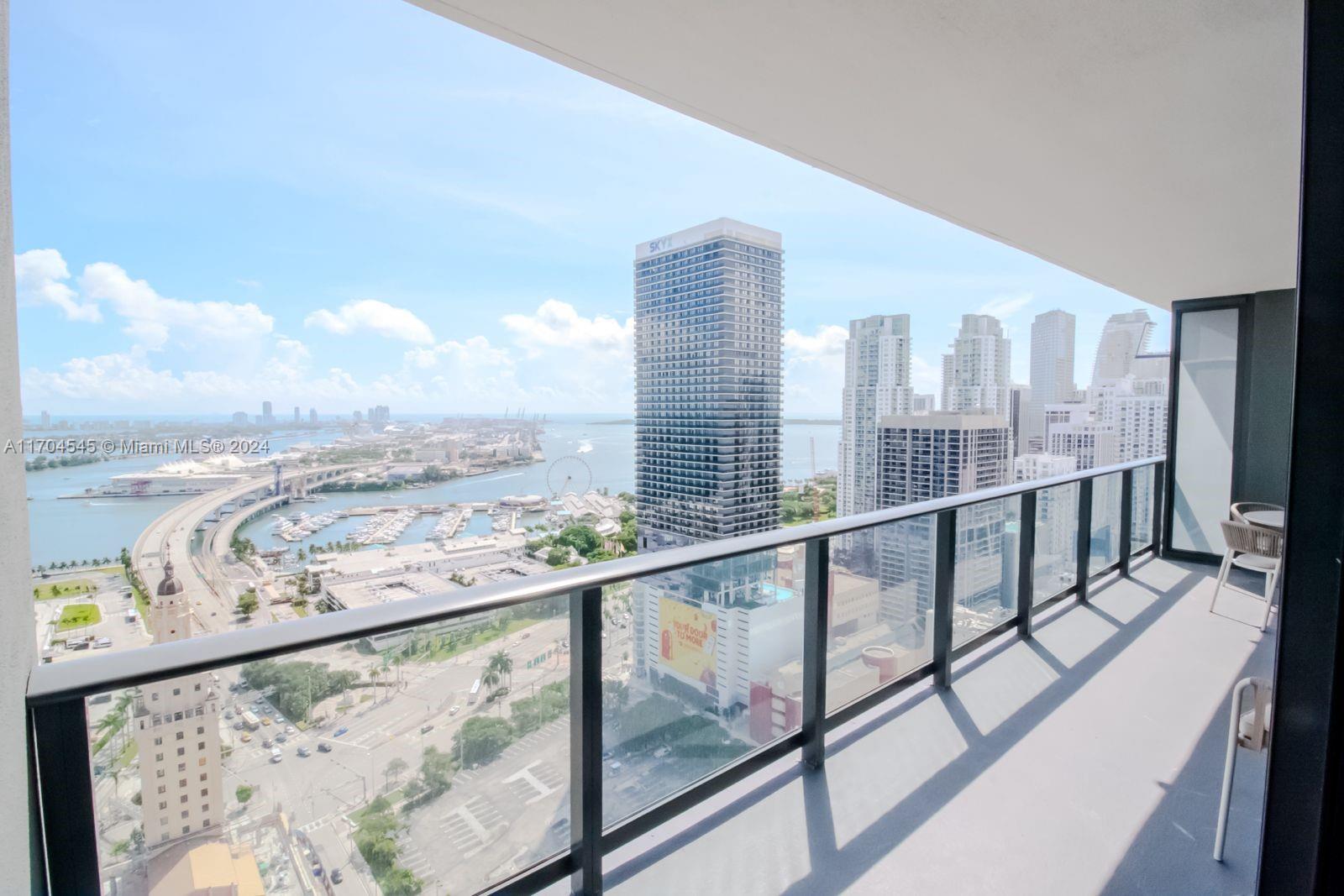 a view of a city from a balcony with furniture