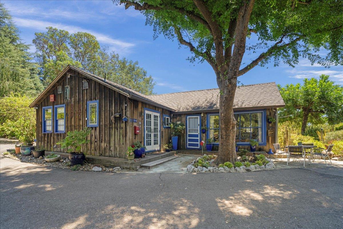 a front view of a house with a tree