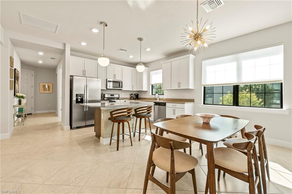 a kitchen with kitchen island a dining table and chairs